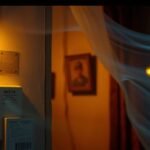 Immagine di un contatore del gas davanti a un contatore dell'elettricità in una vecchia stanza illuminata da una luce gialla