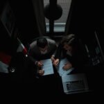 Primo piano di due persone che discutono di procedure immobiliari in un ufficio.