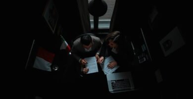 Primo piano di due persone che discutono di procedure immobiliari in un ufficio.